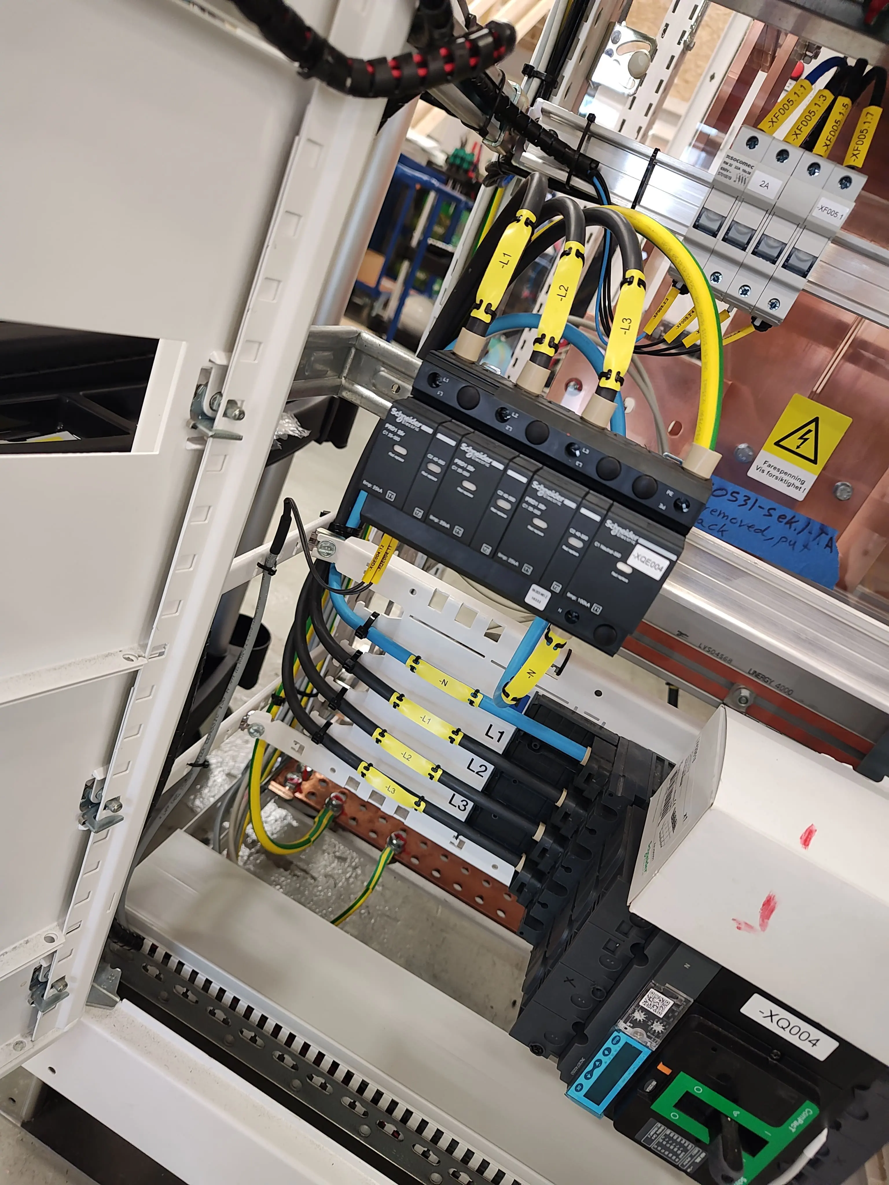 Rozdzielnia elektryczna z modułami Schneider Electric i oznaczonymi przewodami fazowymi. Profesjonalny montaż instalacji elektrycznej w szafie sterowniczej.