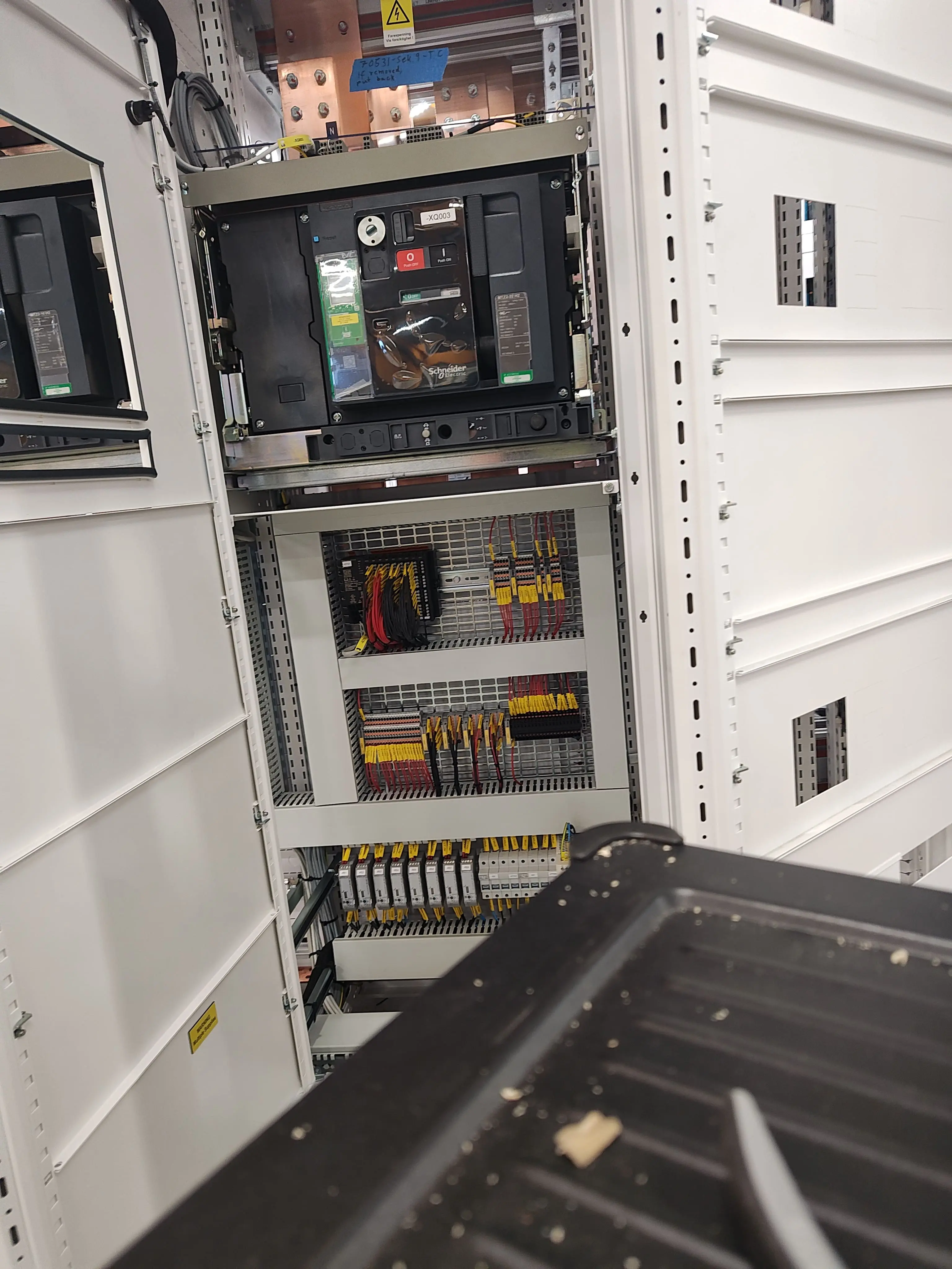 Duża szafa rozdzielcza z automatycznym wyłącznikiem Schneider Electric. Widoczne przewody sterownicze i zabezpieczenia.